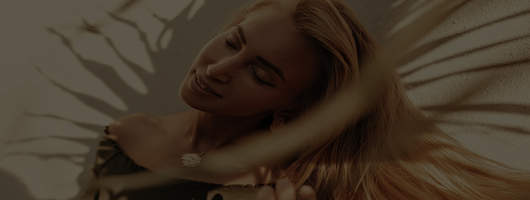 Woman with flowing hair against soft shadow backdrop.