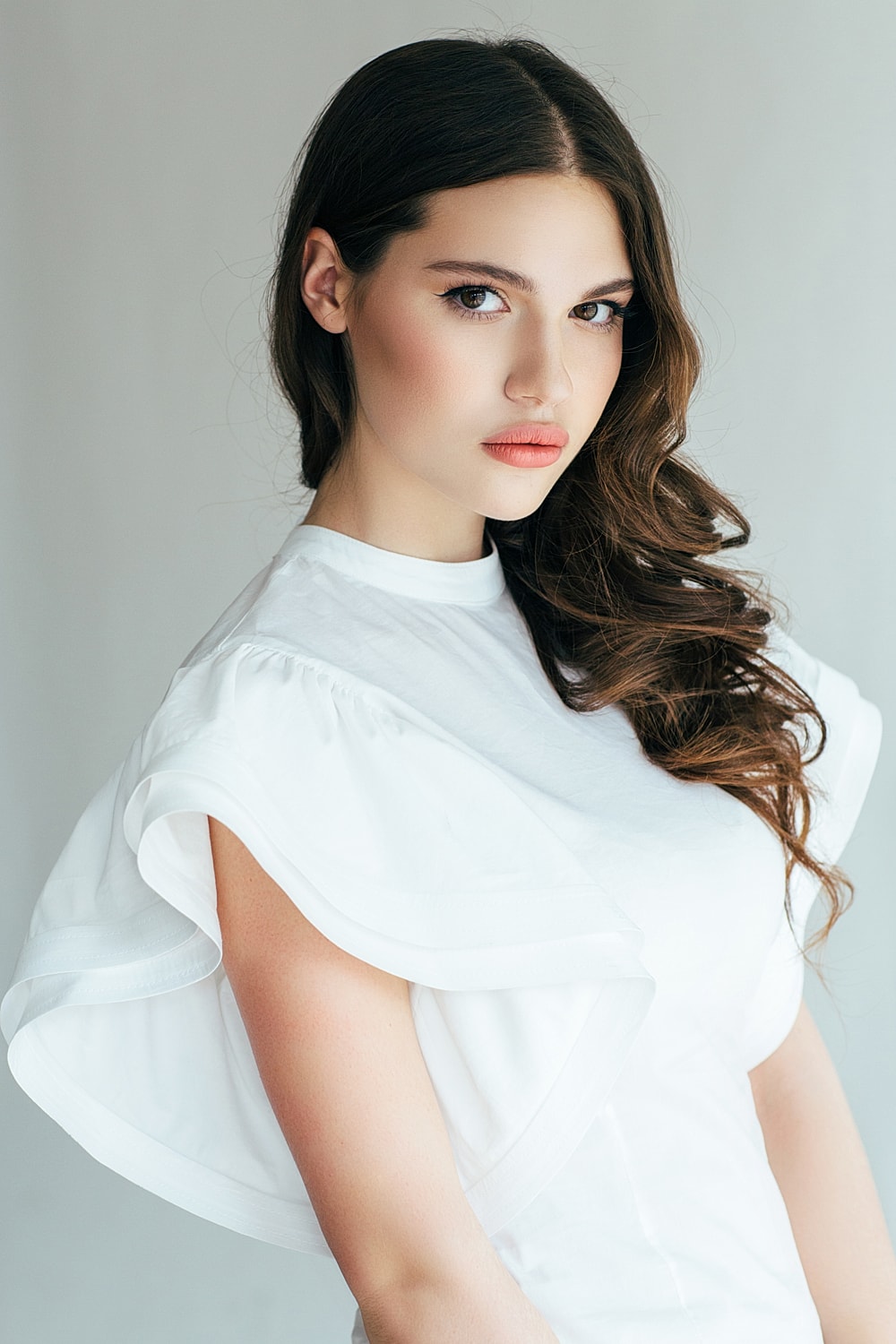 Young woman with long hair and white blouse.